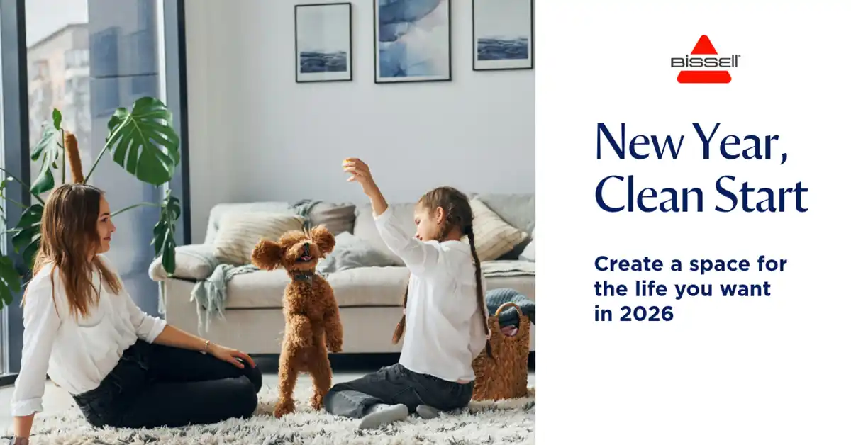 Mother and daughter playing with a small poodle puppy indoors in a modern home, promoting a fresh start for 2026 with BISSELL cleaners.